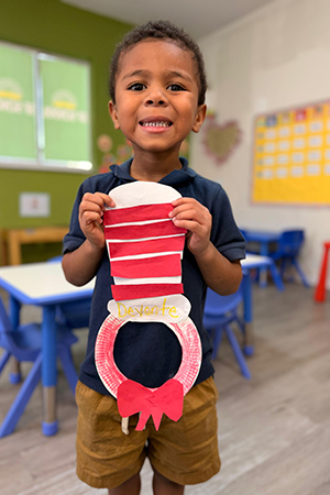 Preschool child holding reading craft activity at early literacy preschool Miami
