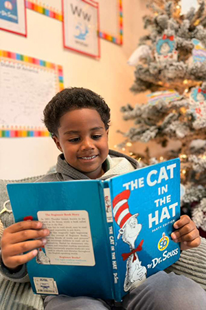 Child reading book independently at early literacy Preschool Miami - SF School Early Literacy